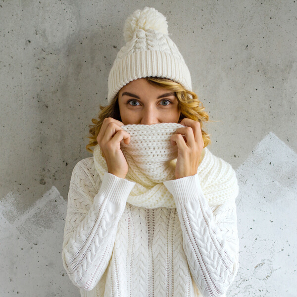 Come Curare i Capelli Durante la Stagione Invernale - Donna con cappellino e sciarpa invernali