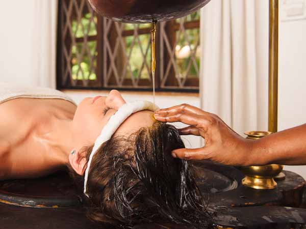 Prodotti per la Cura dei Capelli: massaggio sulla testa di una ragazza con l'olio
